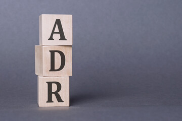 ADR - Adverse Drug Reaction, text written on wooden blocks over gray background.