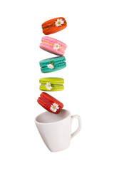 Colorful macaroons levitation on a white tea cup. Food levitation concepts.
