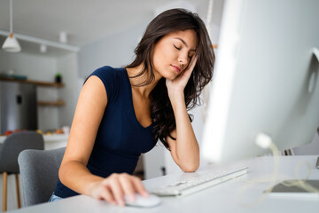 Young and beautiful businesswoman, student tired from work in home office