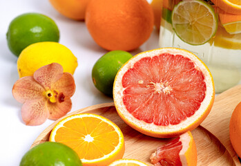 Colorful citrus fruits on a wooden plate.