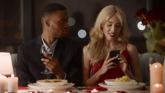 Jealous Boyfriend Suspecting Affair While Girlfriend Using Cellphone In Restaurant