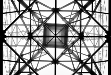 A high-voltage electricity pylons against clear sky and fog