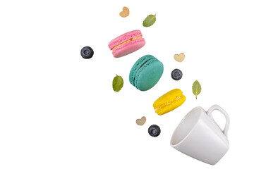 Colorful macaroons  levitating on white background with blueberries and mint leaves. Food levitation concepts.