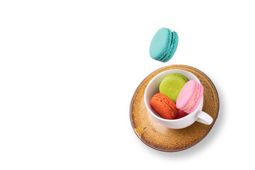 Colorful macaroons  floating on a tea cup and a ceramic plate. Food levitation concepts.
