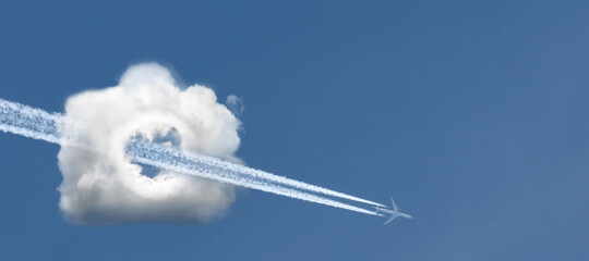 An airplane flying through a cloud in the form of a camera.