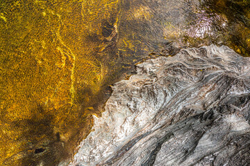 Top view of the water of a river and a rock bank. The wind gives the whole a superb texture.