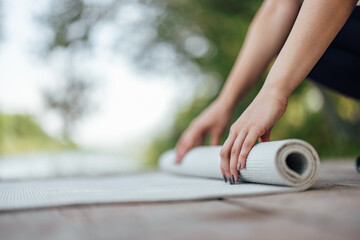 Picture of the hands, opening the yoga mat.