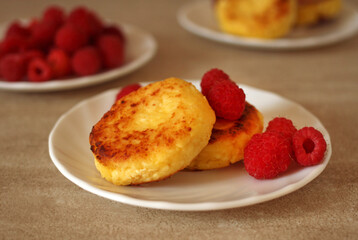Homemade cheesecakes with cottage cheese with fresh raspberries on a beige background