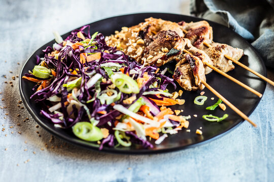 Sate skewers with peanut sauce and red cabbage salad in Thai style