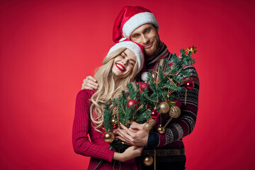 a man and a woman are standing next to the new year tree decoration holiday