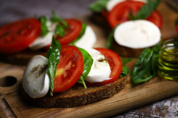 Delicious caprese sandwiches on a wooden board. Keto sandwiches. Italy diet.