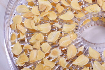Dried garlic flakes or garlic chips. Plate of dried garlic slices. sliced dehydrated garlic clove pieces. New garlic harvest