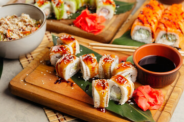 rolls with fish and filling served with soy sauce on a board