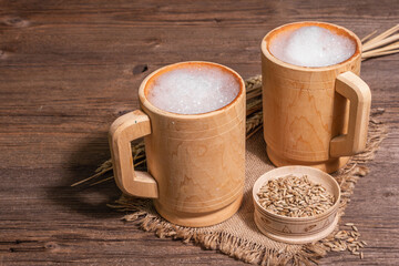 Beer and grain. Oktoberfest concept, wooden mugs on old table