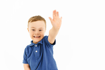Boy with down syndrome smiling and gesturing at camera