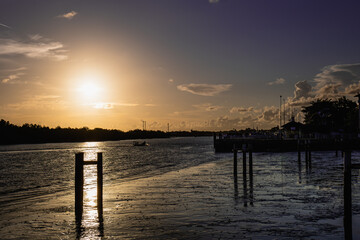 Fototapeta premium The setting sun casts an orange glow and shadows on the harbor.