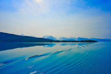 Cruise ships produce ripples on the surface of the lake. Snow-covered mountains. Enjoy the view of the ice shelf from the cruise ship. Alaska, USA. July 2019.