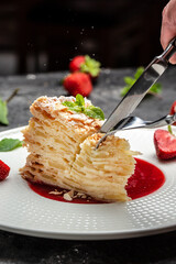 Layered baked pie with creamy vanilla swith cream, apples and strawberry jam decorated mint. vertical image. top view. place for text