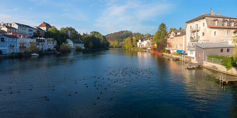 Fototapeta na wymiar Traun river at Gmunden spa town, with houses at the riverside, austria in autumn