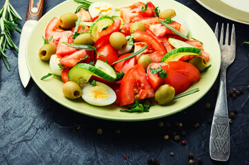 Salad with vegetables, olives, eggs and rosemary
