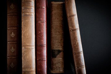 Row of old books on black background