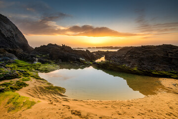 Landscape with sunset over Portuguese West coast and rocky Praia do Vale dos Homens	