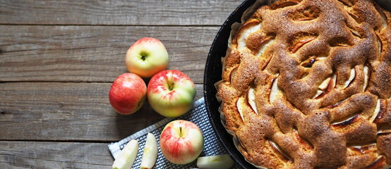 Round apple pie or sponge cake on wooden rustic table. Home cooking.