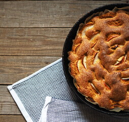 Top view. Round apple pie or biscuit on a wooden rustic table with fresh apples. Homemade healthy food.