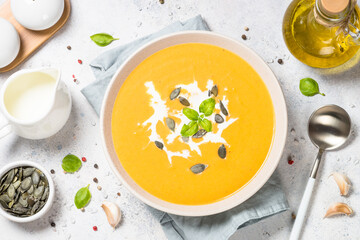Traditionl Pumpkin soup puree with cream. Top view image at white table.