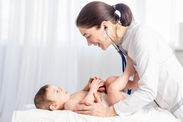 Obraz na płótnie Canvas pediatrics, a doctor examines a baby boy and uses a stethoscope to listen to the baby's heartbeat or breathing, the concept of medicine and health