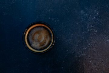 Dark mug of espresso or Americano top view. Black coffee cup on concrete table background. For...