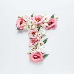 Obraz na płótnie Canvas Letter T made with flower and leaves on bright white background. Floral mother's day alphabet concept. Spring blossom, valentine or romantic font collection. Flat lay, top view.