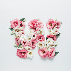 Fototapeta na wymiar Letter W made with flower and leaves on bright white background. Floral mother's day alphabet concept. Spring blossom, valentine or romantic font collection. Flat lay, top view.