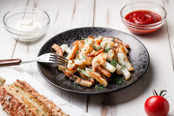 Baked potatoes on a white wooden background. With mayonnaise, ketchup, tomatoes.