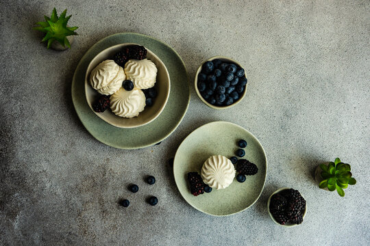 Overhead view of zefir dessert with blueberries and blackberries on a table