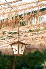 Beautiful rustic lantern on a chain hanging on a canopy