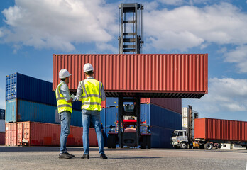 Engineers are overseeing the transportation of cargo with containers inside the warehouse. Container in export and import business and logistics. - obrazy, fototapety, plakaty