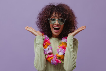 Surprised African curly woman in sunglasses and Hawaiian lei looks into camera. Charming lady...