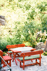 Table with benches stands in a green garden