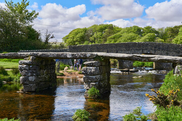 Fototapeta na wymiar Medieval clapper bridge over the East Dart River at Postbridge on Dartmoor in Devon, West Country, England, UK