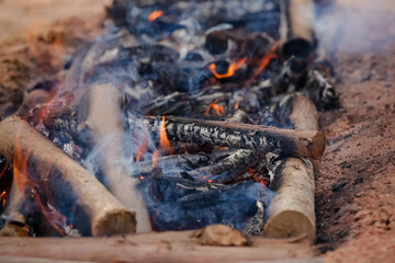 Fogo crepitando no chão, a brasa perfeita para assar carnes, espalhando um aroma irresistível pelo ar.