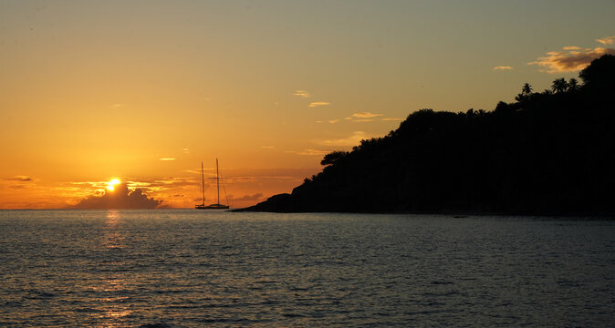 Beautiful view of a sailing boat anchored off the coastline during a beautiful sunset at Fregate Island, Seychelles.
