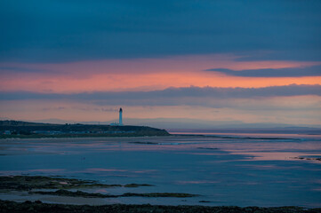 Scottish coastal sunset with lighthouse