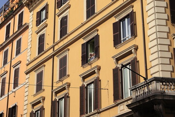 Fototapeta na wymiar Rome Brown Building Facade with Couple at a Window