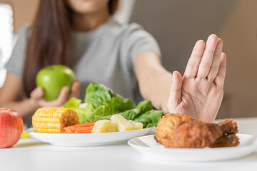 Diet, Dieting young asian woman or girl  push out, deny fried chicken, junk food and choose green apple, vegetables salad, eat food for good healthy, health when hungry. Female weight loss person.