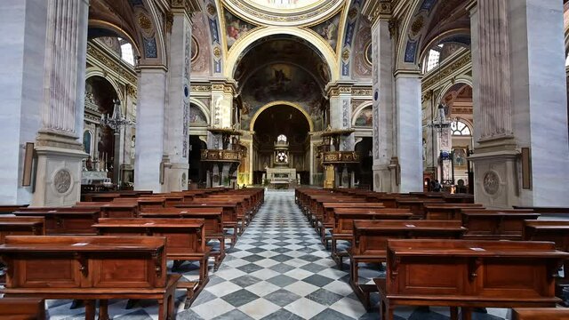 Vigevano, Lombardy, Italy. July 2021. POV shots of the cathedral's enchanting main nave. Walk between the pews towards the altar.