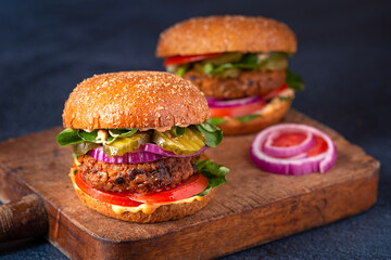 Tow homemade plant based burgers made from sweet potato, black beans and brown rice on a whole wheat brioche bun; copy space