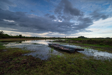 Landschaft mit See und Holzboot