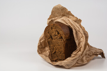 Sliced rye bread on an isolated white background. Slices of brown bread wrapped in brown paper