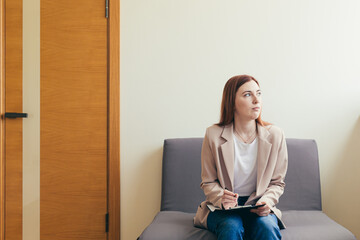 Woman worried in the waiting room corridor, fills out questionnaire tests